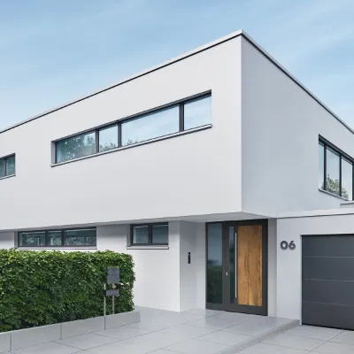 Modernes helles Haus mit einer Haustür aus Aluminium und Holzoptik