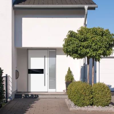 Weiße Haustüre mit silbernem länglichen Griff und Glaselement rechts